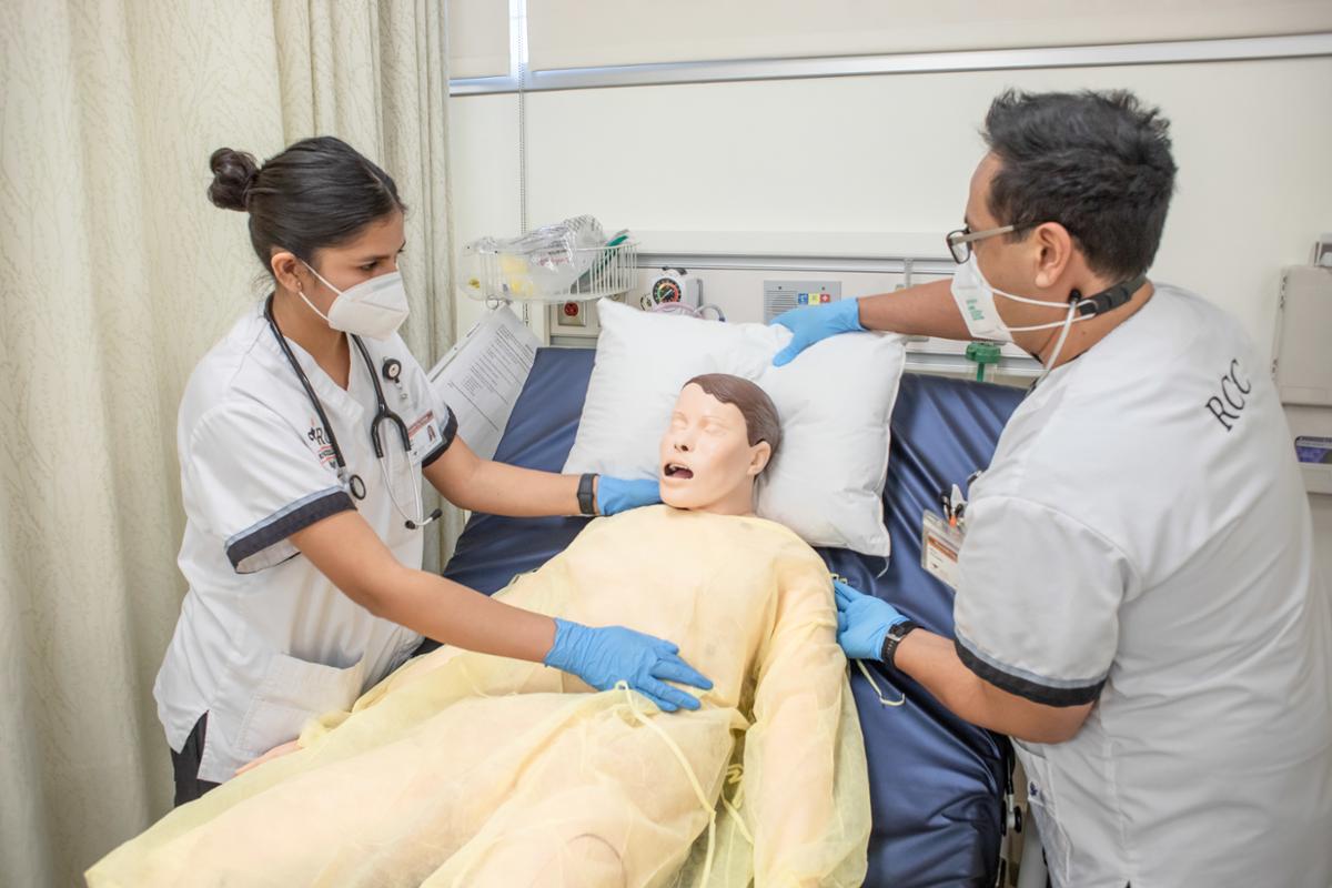 Nursing students caring to a simulation