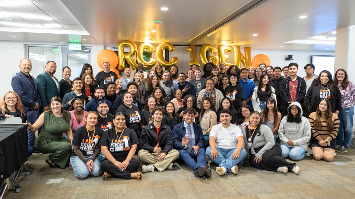 First gen group photo in front of gold balloons reading 1st Gen