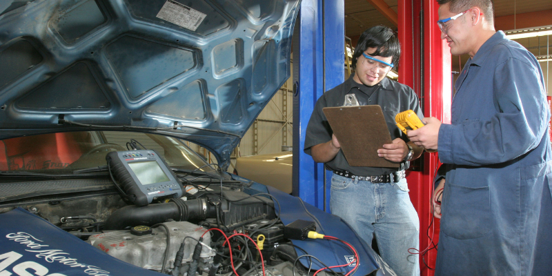 Workforce students working on a car